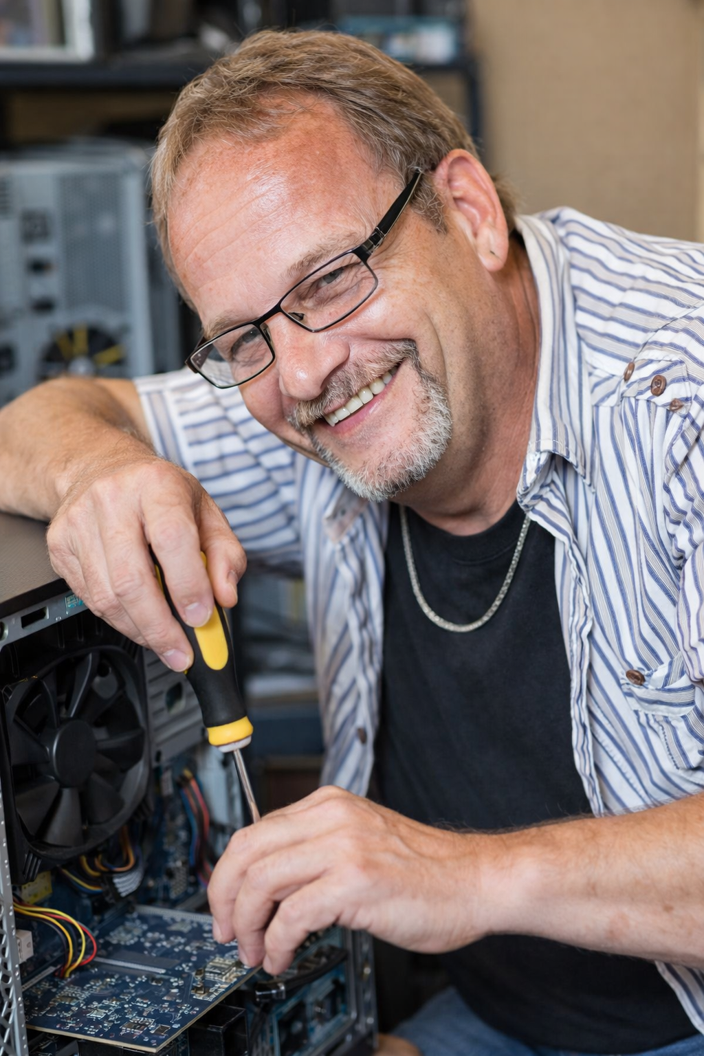 Denis LaCombe réparant un ordinateur